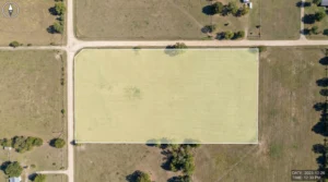 large vacant property lot highlighted on aerial map surrounded by roads and open land